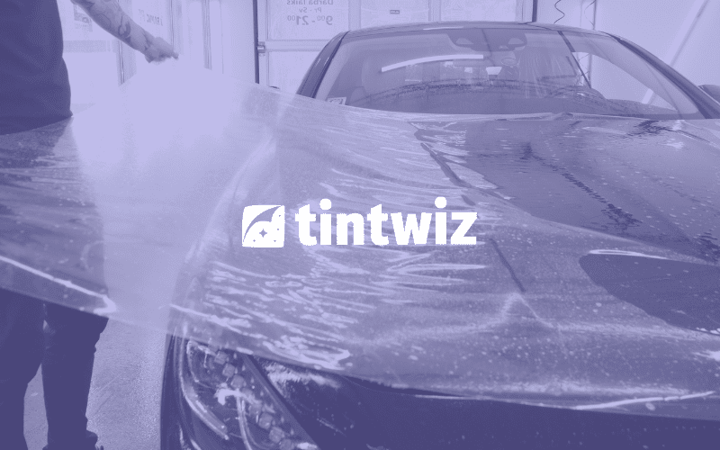 Professional applying paint protection film with the aid of Tint Wiz CRM for streamlined operations